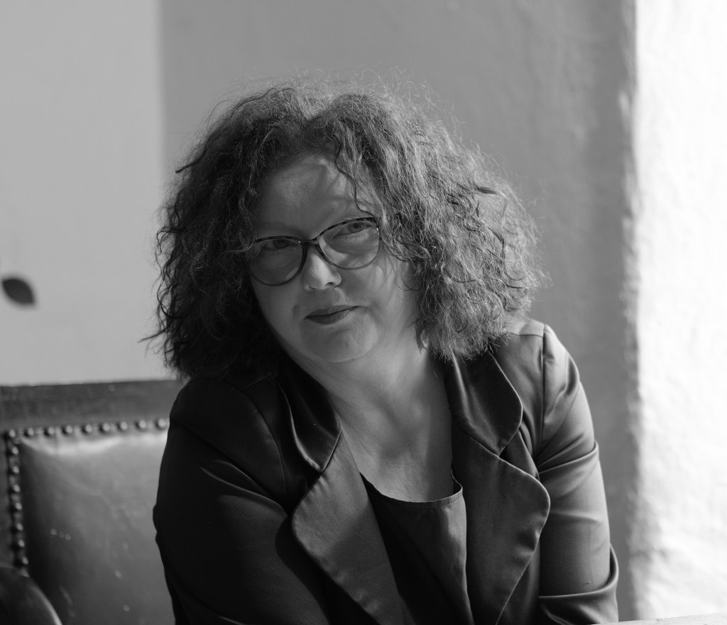 A black and white photo of Catherine looking intensely into the camera.